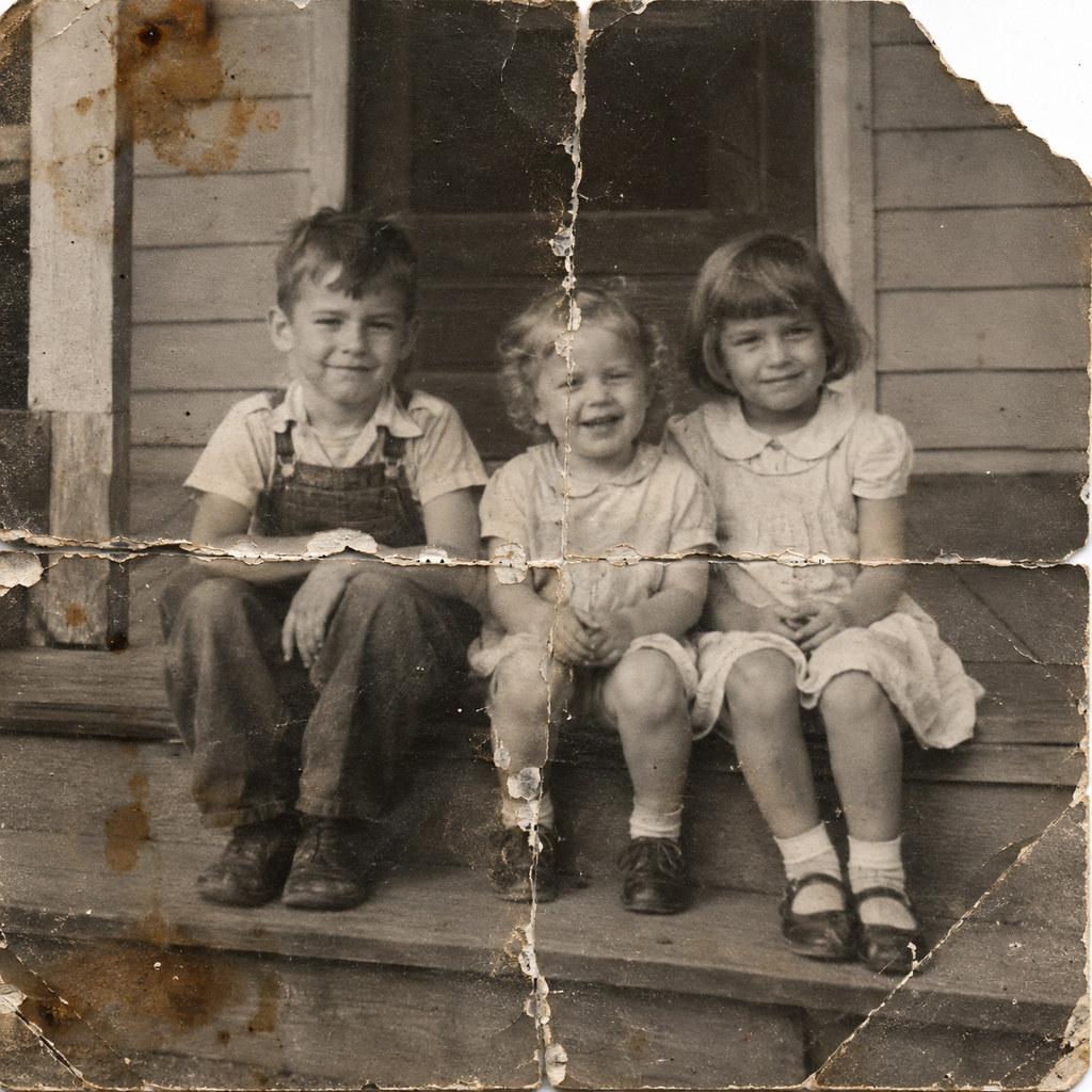 Photo restoration — a creased, faded print repaired, the fold through the frame gone and faces sharp again