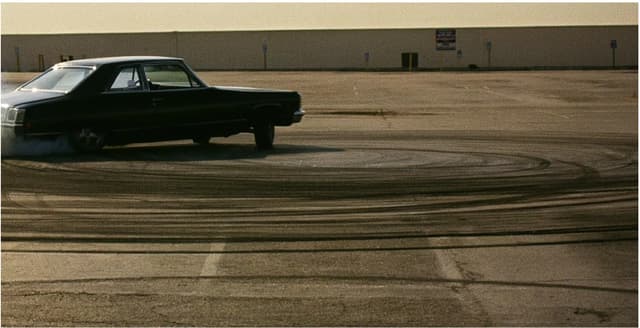 FLUX 3 example — black sedan drifting across an empty lot, photographic style